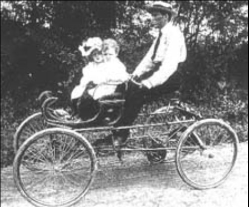 This is a photograph taken in 1902 of J. Warren Jacobs with his two oldest children, Marie and Ben. Jacobs made this innovative, pedal-powered "contraption" just to entertain his children. He called it the "Mule-a-mobile."